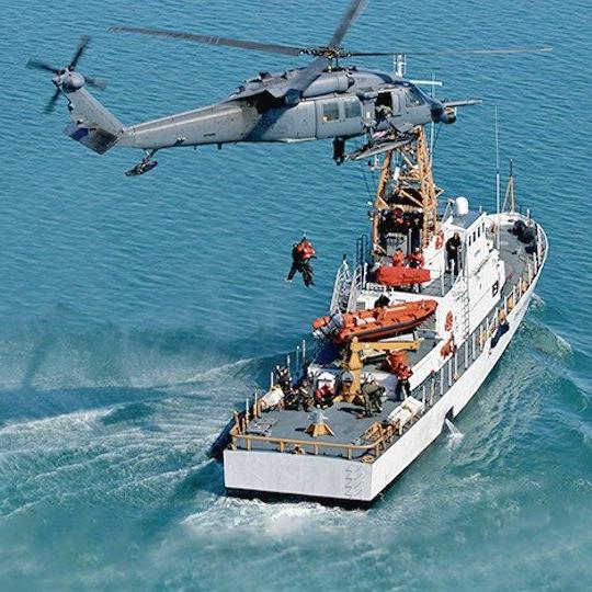 直升机和船只执行搜索和救援任务，在船头可以看到一个海运终端 
